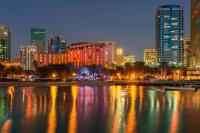 a city skyline at night with a body of water at Sheraton Abu Dhabi Hotel & Resort in Abu Dhabi
