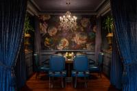 Un comedor con una lámpara de araña y sillas azules. en The Ritz-Carlton, New Orleans, en Nueva Orleans