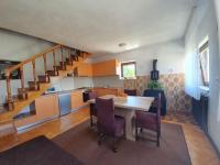 a kitchen with a table and chairs and a staircase at Quiet country side cottage near nature park Velebit in Lovinac