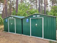 a pair of green storage sheds in the woods at Pension Elfmeter in Rheinsberg