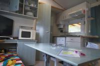 a small kitchen with a table and a microwave at ATLANDES - Entre lac et mer in Biscarrosse
