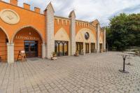 Un gran edificio naranja con un patio de ladrillo. en Puchner Kastélyszálló Prémium, en Bikal