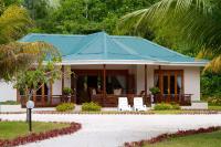 a house with a blue roof and white chairs at Les Villas D&#39;or in Baie Sainte Anne