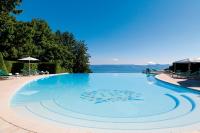 a large swimming pool with a view of the water at Hôtel Royal in Évian-les-Bains