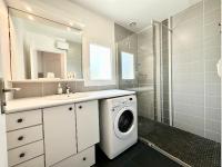 a bathroom with a washing machine and a shower at Maison de pêcheur - À 200m de la plage in Ploemeur