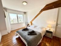 a bedroom with a bed and a large window at Maison de pêcheur - À 200m de la plage in Ploemeur