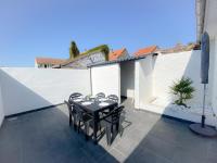 a patio with a table and chairs on a balcony at Les Dunes 1 in Sangatte