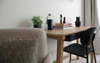 a wooden table with a chair next to a desk with a bottle at FINESTATE Coliving Champs-Elysées in Paris