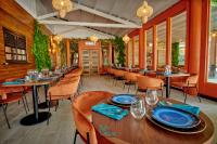 a restaurant with wooden tables and chairs and windows at Village Kawann - Toumalacai 246 in Grand-Bourg