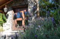 a garden with purple flowers in front of a house at Lares De Chacras in Chacras de Coria