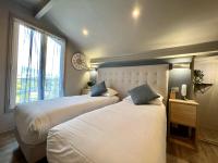 a bedroom with two beds and a large window at Hotel La Calanque in Mandelieu-La Napoule