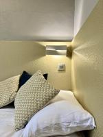a bedroom with a bed with a light on the wall at Hotel La Calanque in Mandelieu-La Napoule