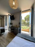 a bedroom with a bed and a desk and a window at Hotel La Calanque in Mandelieu-La Napoule