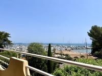 a balcony with a view of a beach and a harbor at Hotel La Calanque in Mandelieu-La Napoule