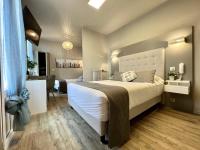 a bedroom with a large bed and a living room at Hotel La Calanque in Mandelieu-La Napoule