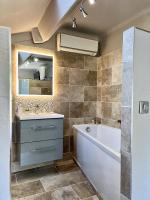 a bathroom with a tub and a sink and a mirror at Hotel La Calanque in Mandelieu-La Napoule