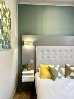 a bedroom with a white bed and a green wall at Hotel La Calanque in Mandelieu-La Napoule