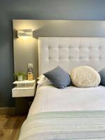 a bedroom with a large bed with a white headboard at Hotel La Calanque in Mandelieu-La Napoule
