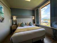 a bedroom with a large bed with a large window at Hotel La Calanque in Mandelieu-La Napoule