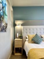 a bedroom with a white bed and a blue wall at Hotel La Calanque in Mandelieu-La Napoule