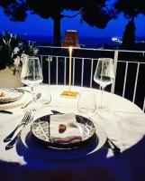 a table with a plate of food and wine glasses at Tra gli Alberi e il Mare in Sirolo