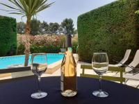 a bottle of wine and two glasses on a table at Magnifique maison de campagne au cœur d&#39;un domaine viticole in Cazouls-lès-Béziers