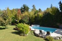 a swimming pool in a yard with chairs and trees at Lares De Chacras in Chacras de Coria