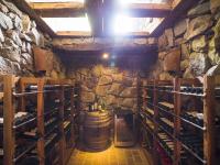 a wine cellar with a barrel and a stone wall at Lares De Chacras in Chacras de Coria