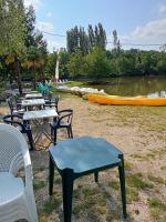 a group of tables and chairs next to a lake at mobil-home du lac de Foix in Foix