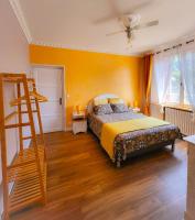 - une chambre dotée d&#39;un lit avec un mur jaune dans l&#39;établissement La Note Verte Pause en ville, à Foix