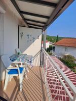 a balcony with a table and chairs and a mural at Apartment RB in Omišalj