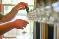 una persona tiene in mano un bicchiere di vino di Westfir Lodge & Mountain Market a Oakridge