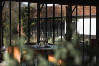 Una mesa con vasos encima en una habitación con ventanas. en La Grenouillère, en Montreuil-sur-Mer
