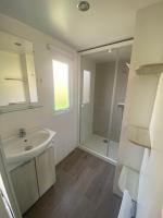 a white bathroom with a sink and a shower at Mobil Home 4 personnes in Narbonne-Plage