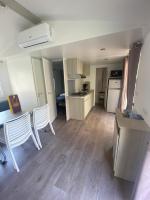a room with a kitchen and a table and chairs at Mobil Home 4 personnes in Narbonne-Plage