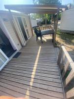 a wooden walkway with a bench on a deck at Mobil Home 4 personnes in Narbonne-Plage