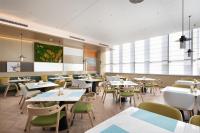 uma sala de jantar com mesas, cadeiras e janelas em Home2 Suites by Hilton Beijing Shunyi em Shunyi