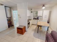 a kitchen with white cabinets and a table and a table and chairs at Appartement Menton, 2 pièces, 4 personnes - FR-1-196-336 in Menton