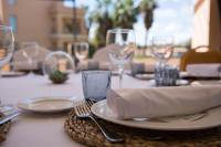 a table with a plate and fork and wine glasses at Hotel Alicante Golf in Alicante