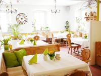 a restaurant with white tables and chairs with green accents at Apartments Erbgericht in Bad Schandau
