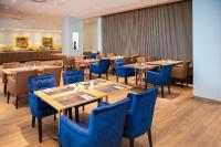 Un comedor con mesas y sillas azules. en Müggelseeperle, en Berlín