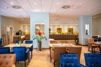 Un restaurante con mesas y sillas y un mostrador. en Müggelseeperle, en Berlín