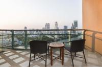 a balcony with two chairs and a table and a view at Chatrium Hotel Riverside Bangkok in Bangkok