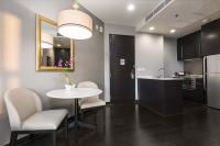 a kitchen with a table and chairs and a mirror at Chatrium Hotel Riverside Bangkok in Bangkok