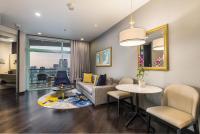 a living room with a couch and a table at Chatrium Hotel Riverside Bangkok in Bangkok