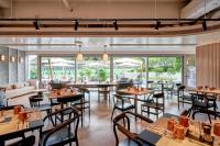 um restaurante com mesas, cadeiras e janelas em the Arca em Hong Kong