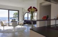 a living room with a table and chairs with a vase of flowers at Séjour de Luxe à Golfe Juan, 15 mn de Cannes in Vallauris