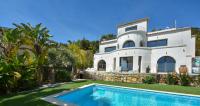 a large white house with a swimming pool in front of it at Séjour de Luxe à Golfe Juan, 15 mn de Cannes in Vallauris