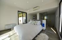 a bedroom with a white bed and a large window at Séjour de Luxe à Golfe Juan, 15 mn de Cannes in Vallauris
