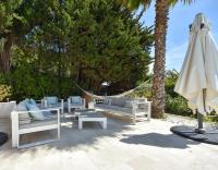 a patio with a hammock and an umbrella at Séjour de Luxe à Golfe Juan, 15 mn de Cannes in Vallauris